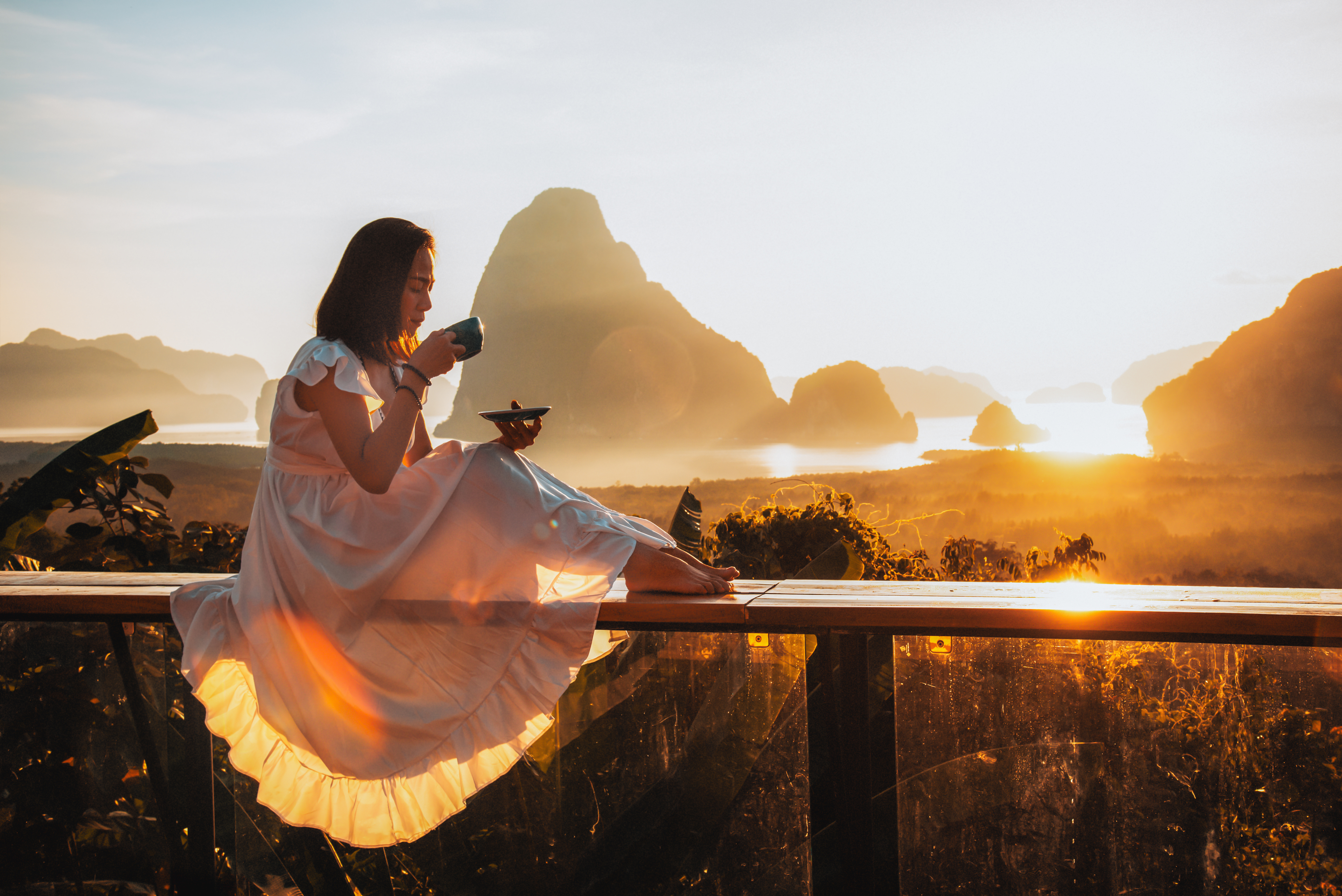 Woman drinking coffee at golden hour sunrise